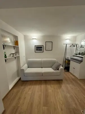 a living room with a couch and wooden floors at Urban Oasis in Rome