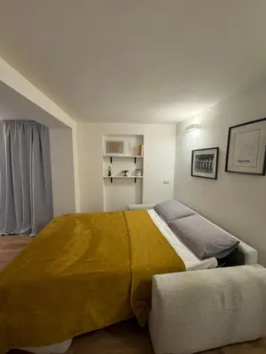 a bedroom with a large bed with a yellow blanket at Urban Oasis in Rome