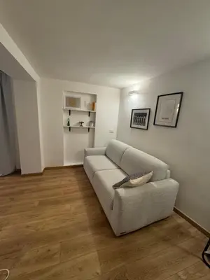 a living room with a couch and wooden floors at Urban Oasis in Rome