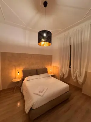 a bedroom with a white bed and a light fixture at Unam Apartment Roma in Rome