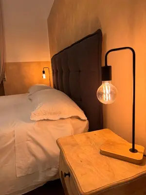 a bedroom with a bed and a table with a lamp at Unam Apartment Roma in Rome