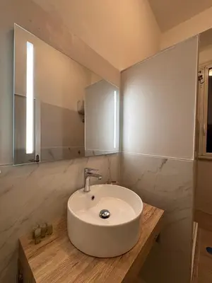 a bathroom with a white sink and a mirror at Unam Apartment Roma in Rome