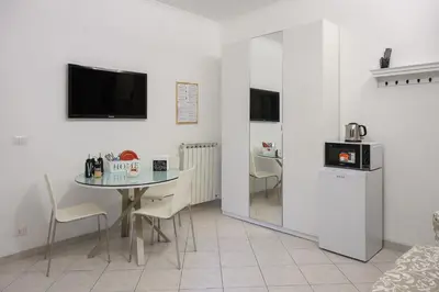 a dining room with a table and a tv on the wall at Triple room a few steps from Tiber in Rome