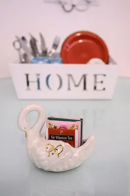 a pink glass swan holder with a box and a plate at Triple room a few steps from Tiber in Rome