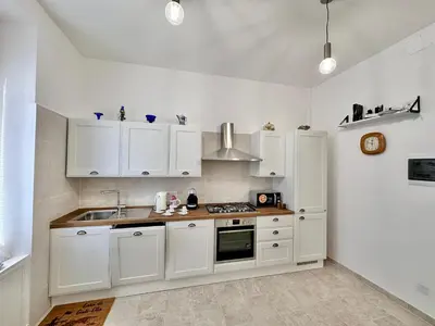 a kitchen with white cabinets and a sink at Giuli-Etta a Testaccio in Rome