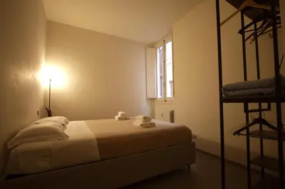 a small bedroom with a bed and a window at Cartari Holiday House in Campo de Fiori in Rome