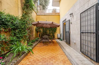 a patio with a table and an umbrella at Appartamento con terrazza vicino S Pietro in Rome