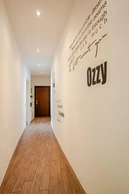 a hallway with a white wall with a sign on it at Appartamento con terrazza vicino S Pietro in Rome