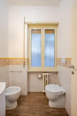 a bathroom with a toilet and a sink and a window at Appartamento con terrazza vicino S Pietro in Rome