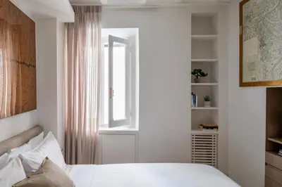 a bedroom with a white bed and a window at Vittoria apartment BDB in Rome