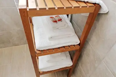 a wooden towel rack in a bathroom with towels at White Wood House in Rome