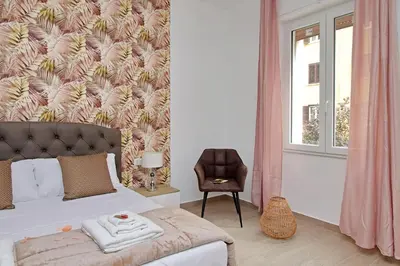 a bedroom with a bed with a pink wall at White Wood House in Rome