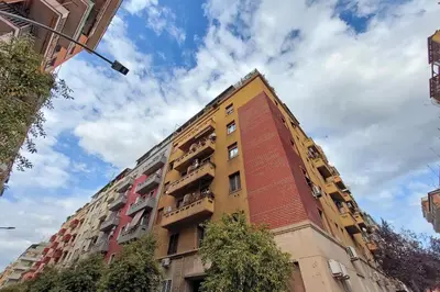a tall yellow building with balconies on it at White Wood House in Rome