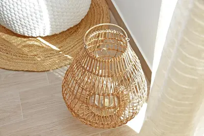 a rattan basket sitting on the floor next to a straw hat at White Wood House in Rome