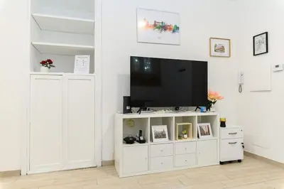 a living room with a tv on a white entertainment center at La Scaletta Furio Camillo in Rome