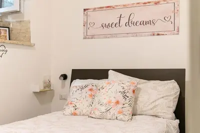 a bedroom with a bed with a sign that reads sweet dreams at La Scaletta Furio Camillo in Rome