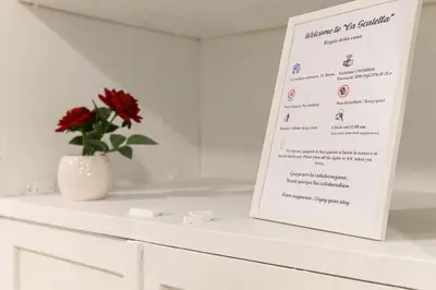 a menu on a white counter with a flower in a vase at La Scaletta Furio Camillo in Rome