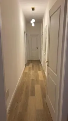 an empty hallway with a white door and wooden floors at Vatican suite Rhome in Rome