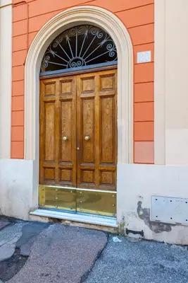 a wooden door on a building with an arch at Colosseo 85 in Rome