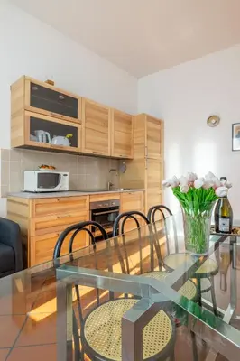 a kitchen with a glass table and some chairs at Colosseo 85 in Rome