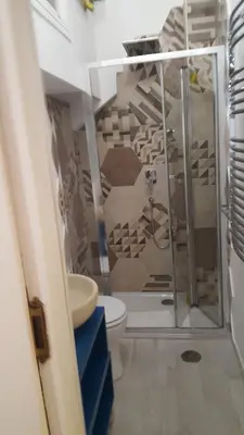 a bathroom with a shower and a toilet in it at Merulana Suite Apartment in Rome