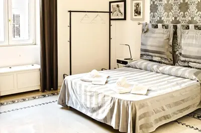 a bedroom with a bed with towels on it at Merulana Suite Apartment in Rome