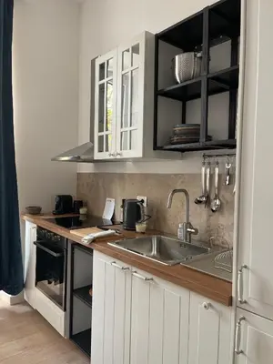 a kitchen with white cabinets and a sink at Casa Sara in Rome