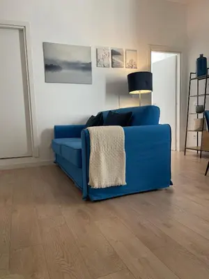 a blue couch in a living room with a wooden floor at Casa Sara in Rome