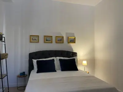 a bedroom with a large bed with two blue pillows at Casa Sara in Rome