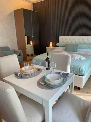 a white table with chairs and a bottle of wine at Mary St Peter Vatican Loft in Rome