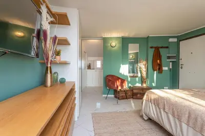 a bedroom with green walls and a bed and a desk at Radice Home in Rome