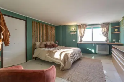 a bedroom with green walls and a bed and a window at Radice Home in Rome