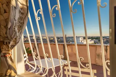 a balcony with a view of the beach and buildings at Radice Home in Rome
