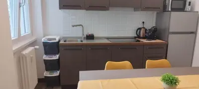 a kitchen with a sink and a counter with yellow chairs at Eve&Gio Apartment Appio 2 room 2 bath in Rome