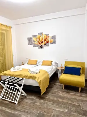 a bedroom with two beds and a yellow chair at Eve&Gio Apartment Appio 2 room 2 bath in Rome