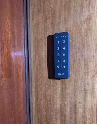 a blue remote control on a wooden door at Eve&Gio Apartment Appio 2 room 2 bath in Rome