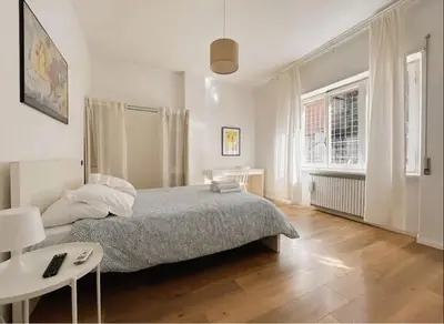 a bedroom with a bed and a desk and a window at Vatican House big in Rome