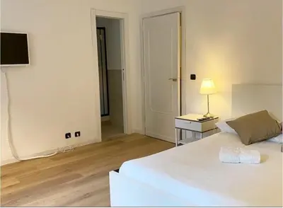 a bedroom with a white bed and a table with a lamp at Vatican House big in Rome