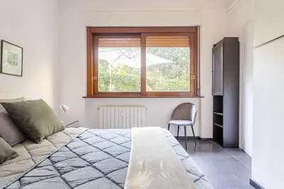 a bedroom with a bed and a window and a chair at Fleming hill apartments - Free Private Parking & Garden in Rome