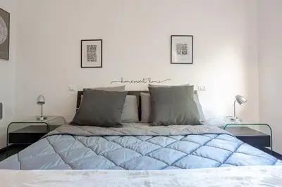 a white bedroom with a large bed with two lamps at Fleming hill apartments - Free Private Parking & Garden in Rome
