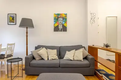a living room with a couch and a painting on the wall at Fleming hill apartments - Free Private Parking & Garden in Rome