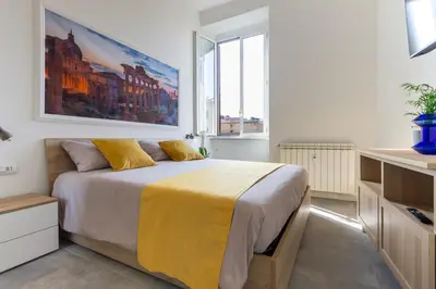 a bedroom with a large bed with a yellow blanket at Peace Window Roma in Rome