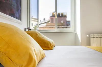 a bed with two pillows sitting next to a window at Peace Window Roma in Rome