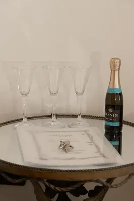three wine glasses and a bottle on a table at Domus Massimiliani Guesthouse in Rome