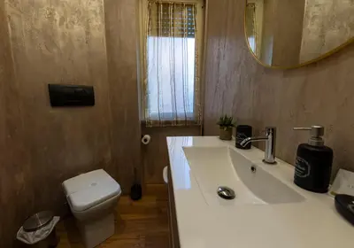 a bathroom with a sink and a toilet and a mirror at Liu Home Tiburtina Stay in Rome in Rome