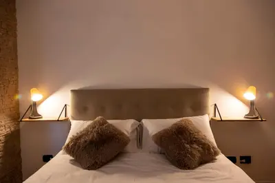 a bedroom with a bed with two lamps on it at Liu Home Tiburtina Stay in Rome in Rome