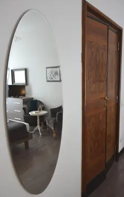 a mirror reflecting a living room with a wooden door at Nobilcasa Suites in Rome