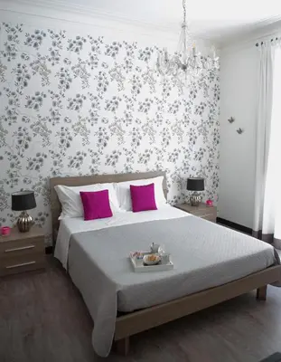 a bedroom with a large bed with pink pillows at Nobilcasa Suites in Rome