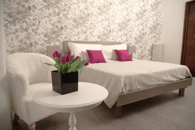 a bedroom with a bed with pink pillows and a table at Nobilcasa Suites in Rome
