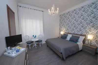 a bedroom with a bed and a tv and a table at Nobilcasa Suites in Rome